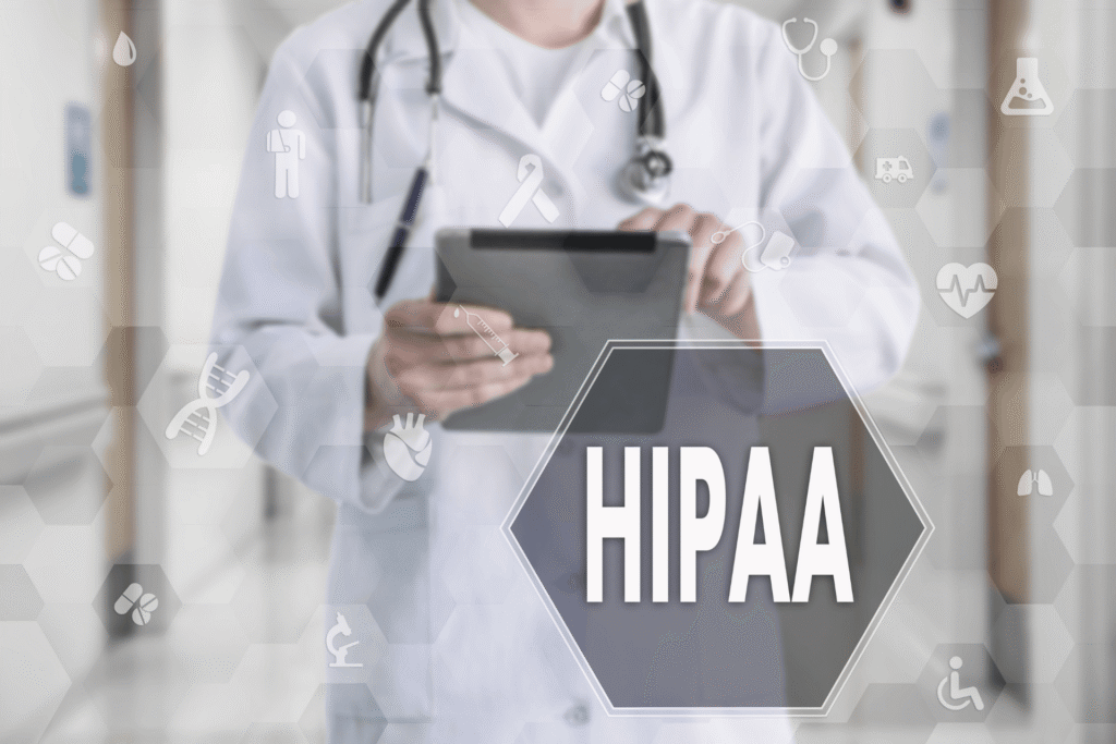Doctor in a white coat using a tablet in a hospital setting, with medical icons overlaid and the word “HIPAA” displayed prominently in a hexagon graphic.